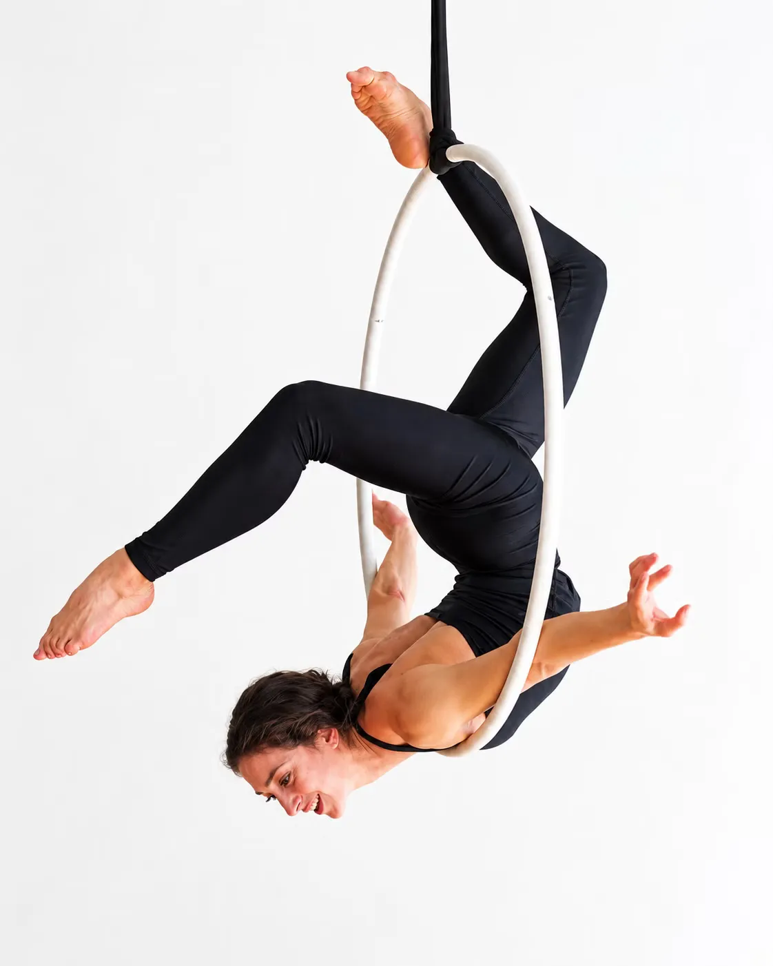 Mulher em uma figura acrobática no aro aéreo